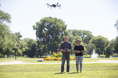 Northern Illinois University Assistant Professor Thomas Pingel (right) Andrea Saavedra work with their drone. (NIU/Scott Walstrom photo)